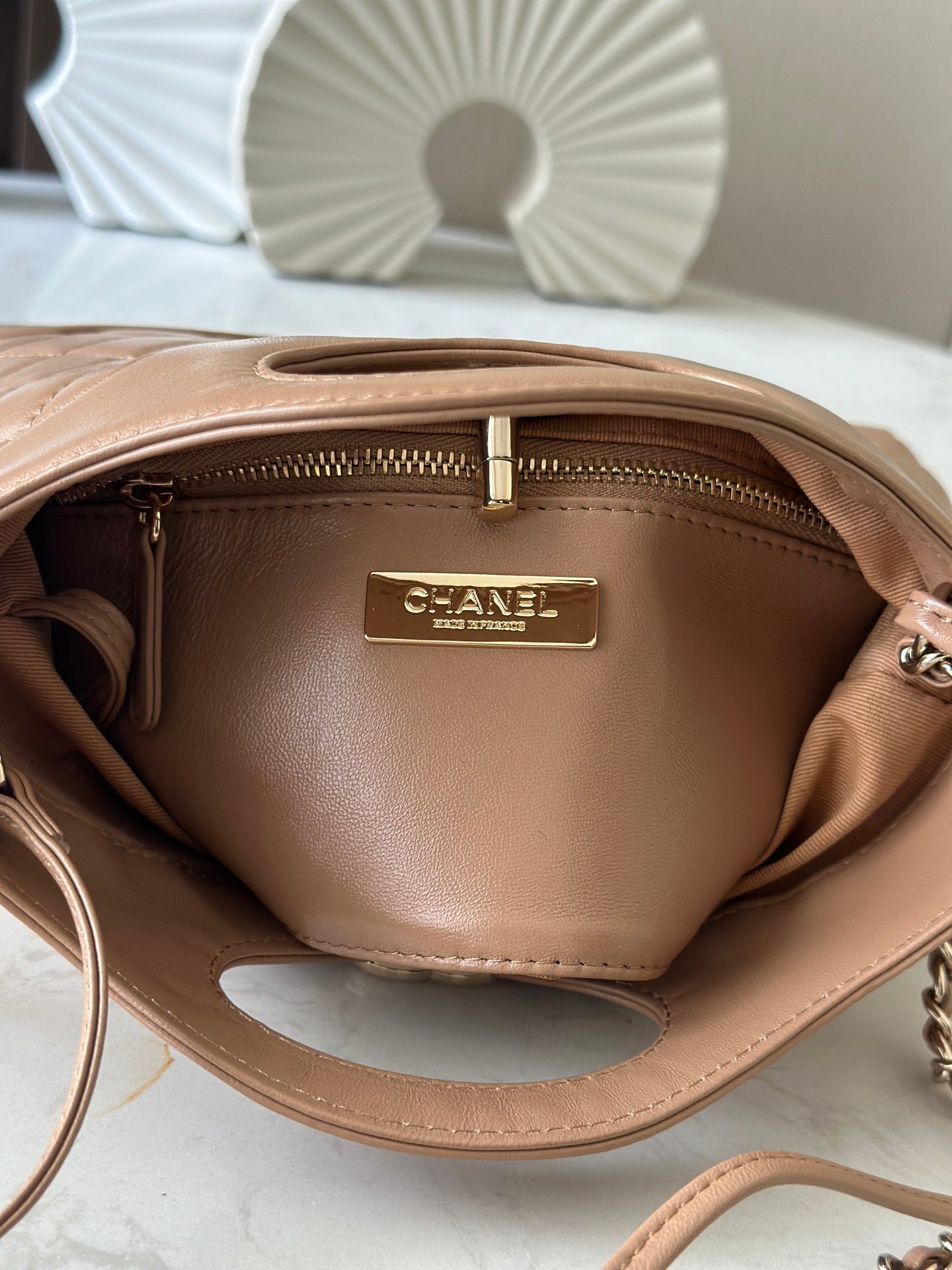 Chanel handbag interior with gold logo plate and zippered pocket