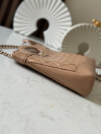 Chanel quilted beige handbag angled view with chain strap and curved base