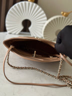 Chanel beige handbag opened to show interior with chain strap