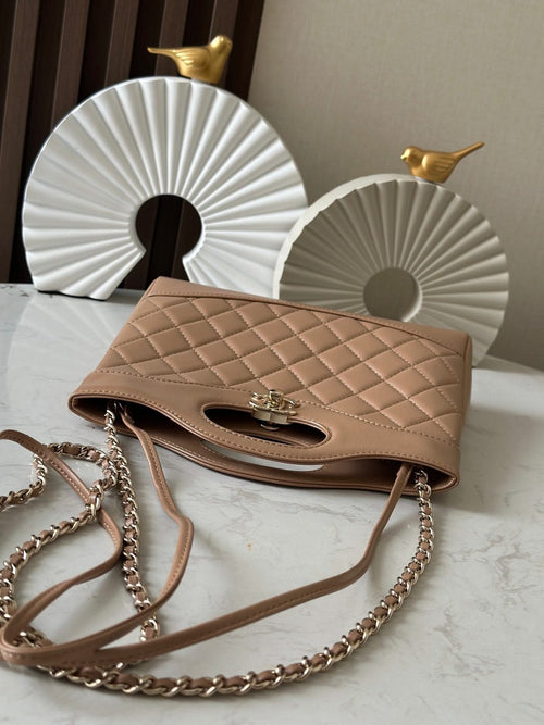 Chanel quilted beige handbag with flap top, gold clasp, and chain shoulder strap