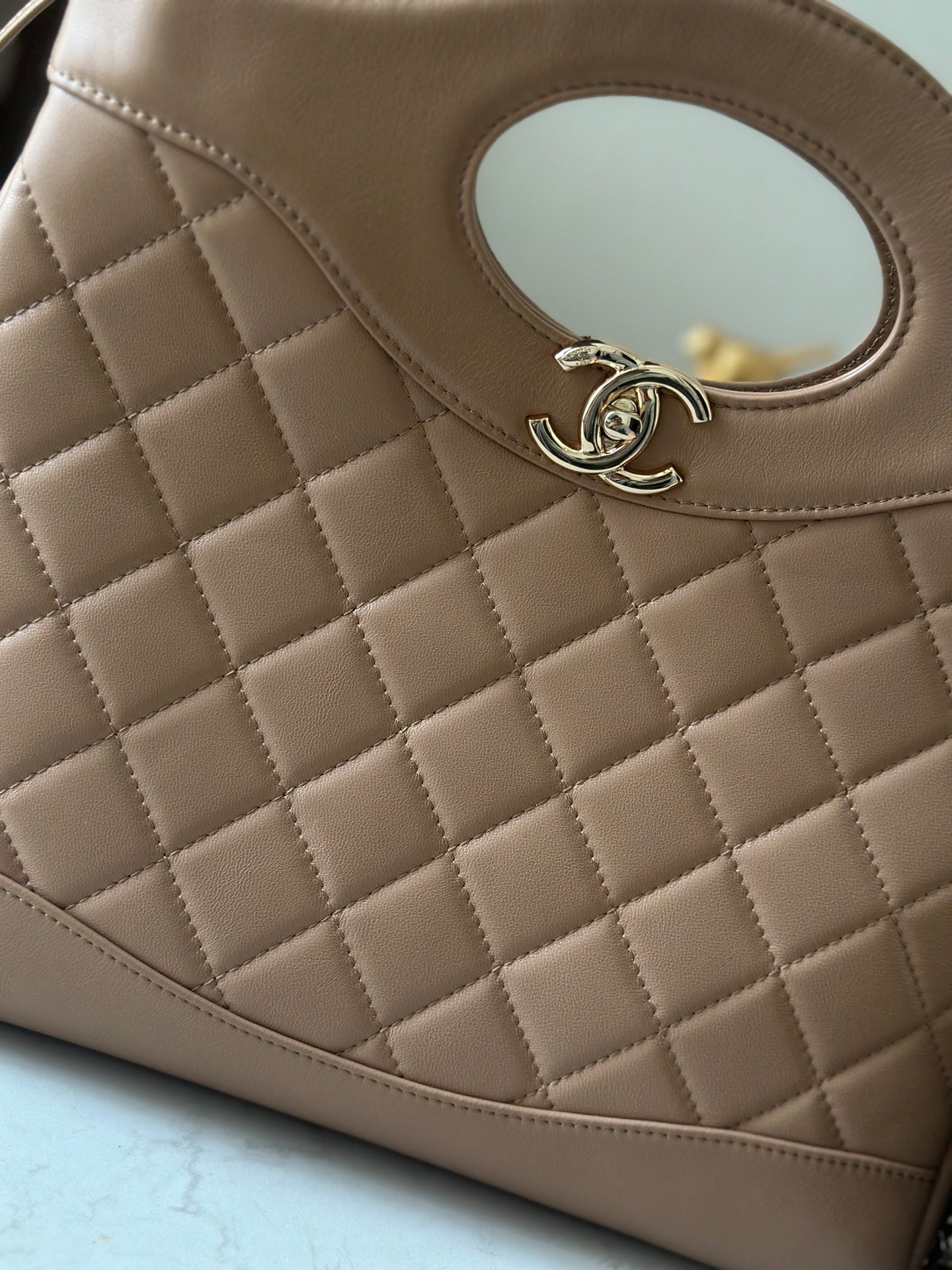 Chanel quilted leather bag with oval cutout and CC logo detail, light beige