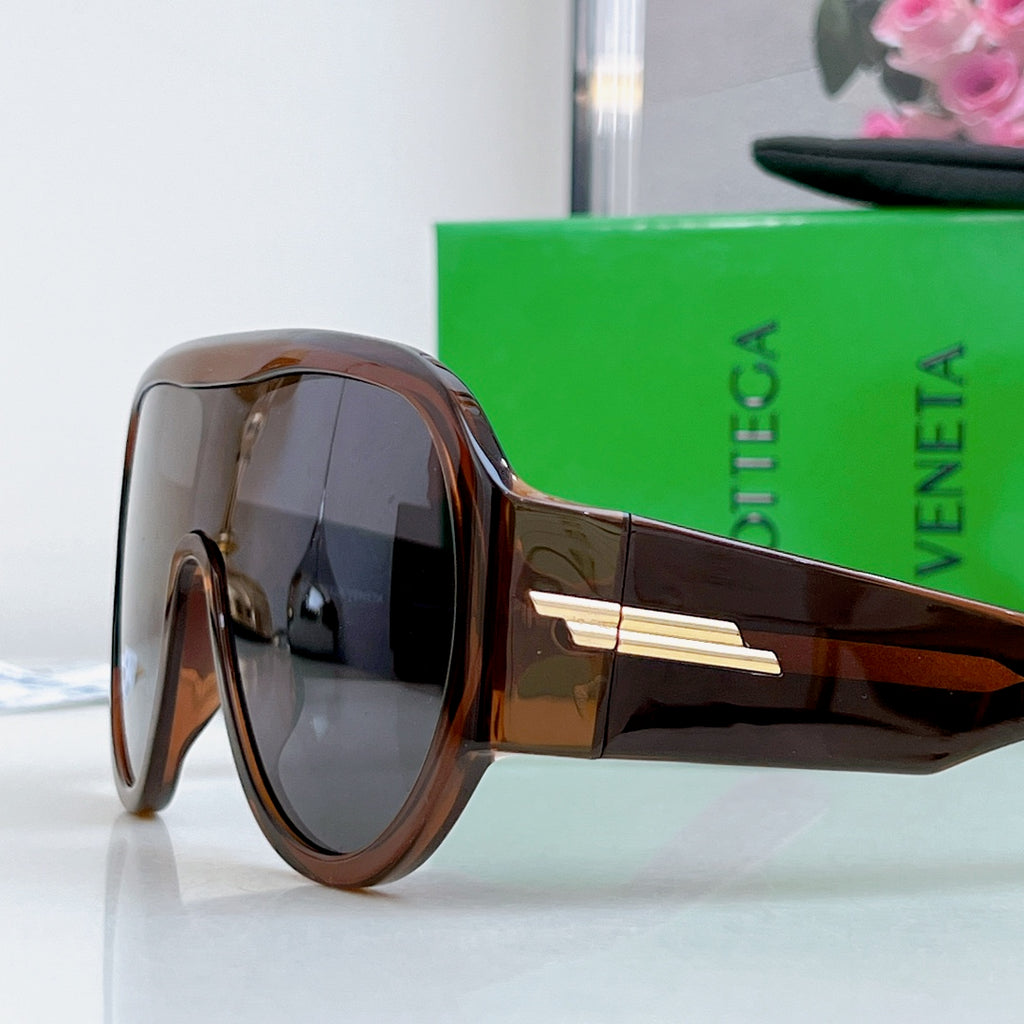 Brown-tinted sunglasses with dark side frame and gold-tone bridge bar