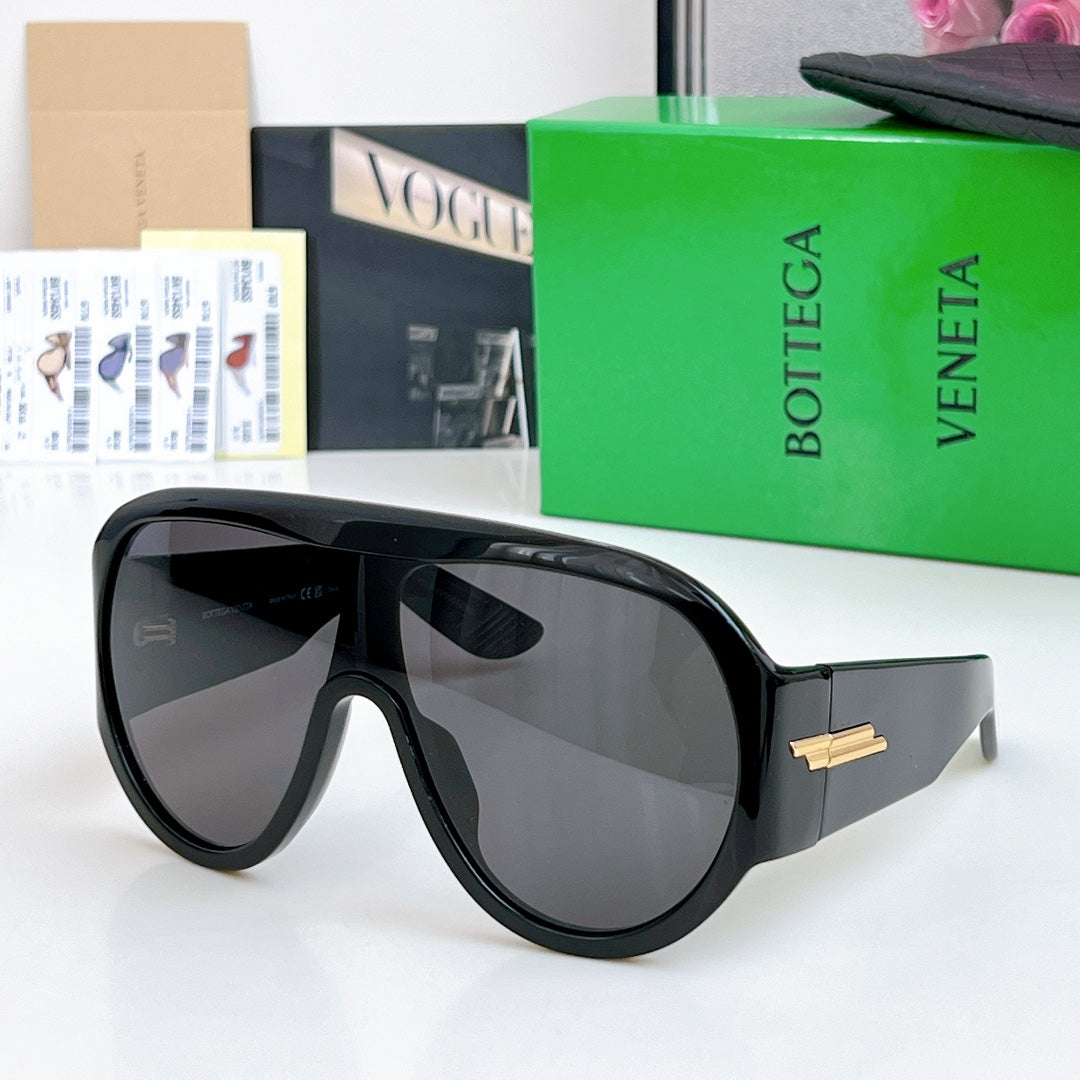 Black sunglasses with dark gray lenses and gold-tone bar detail