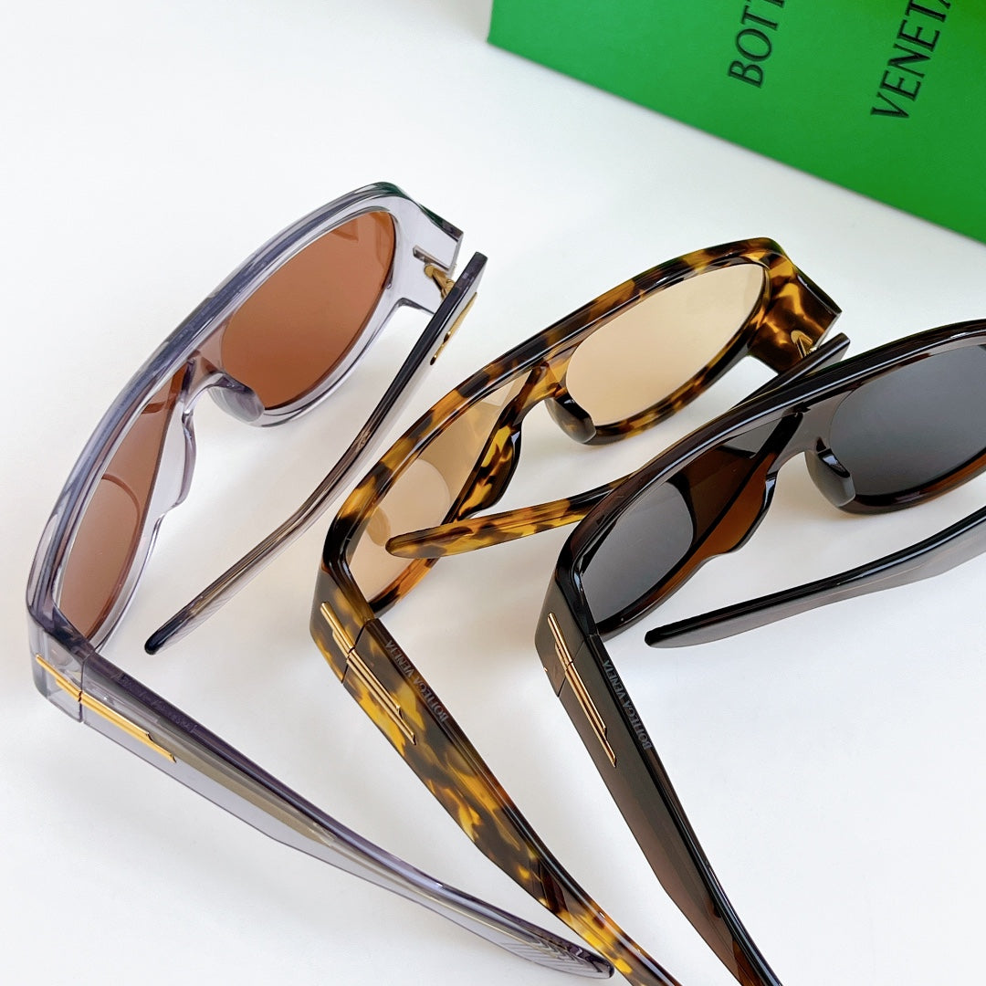 Pair of sunglasses with clear frame and tortoise frame, side gold-tone bars