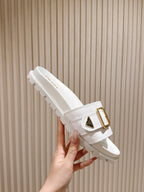 White Prada unisex slide sandals with gold buckle detail and tread sole