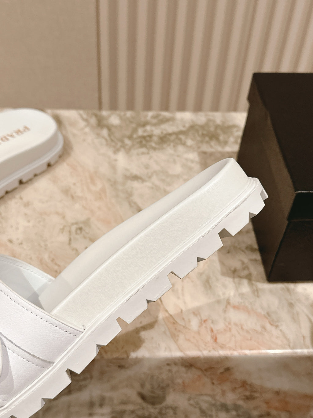 White Prada unisex slide sandals showing thick outsole tread