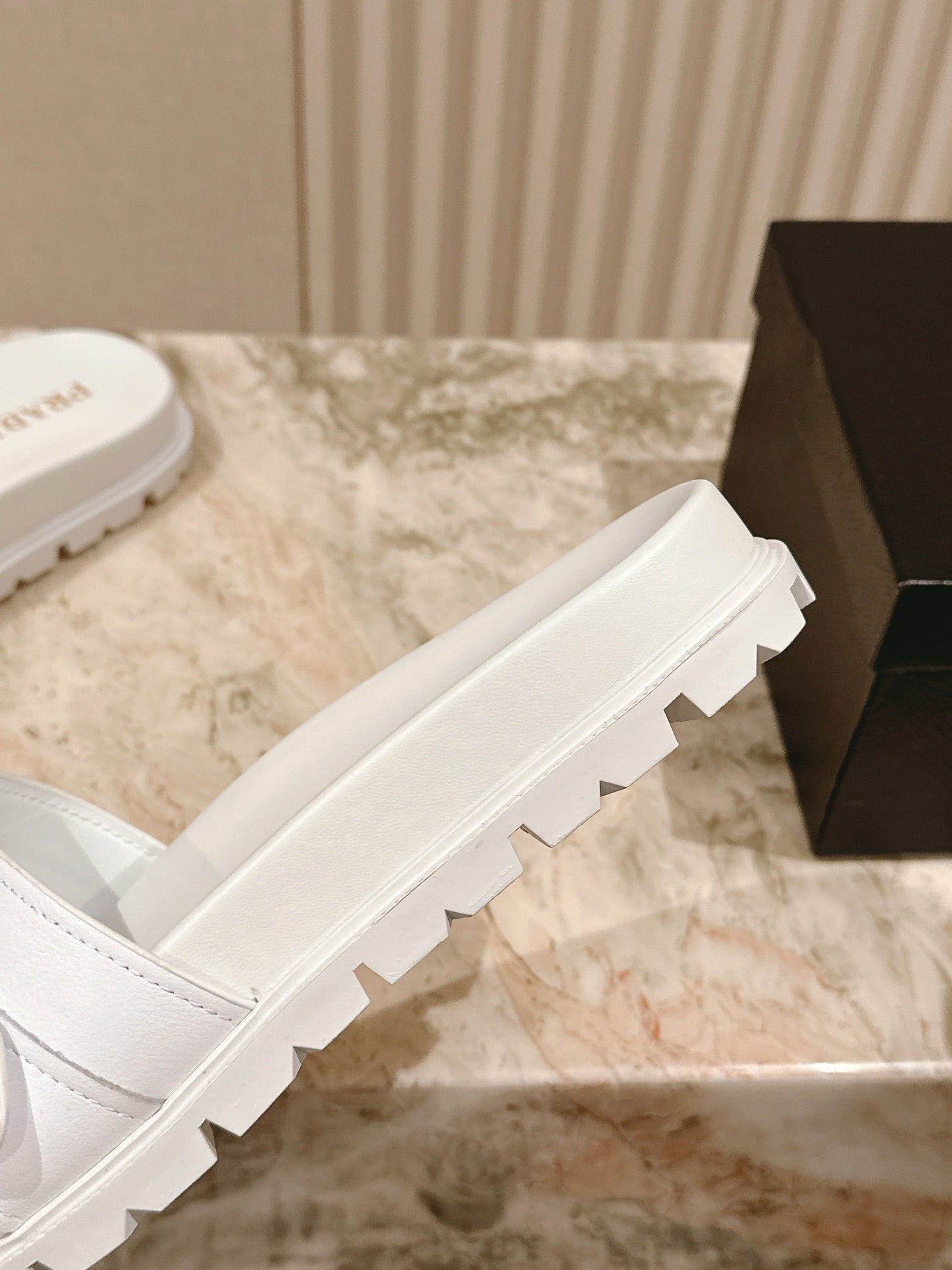 White Prada unisex slide sandals showing thick outsole tread
