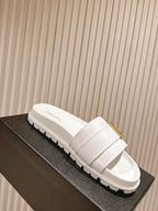 White Prada unisex slide sandals with gold buckle on chunky sole