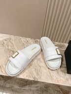White Prada unisex slide sandals with gold buckle across the strap
