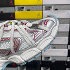 Balenciaga sneaker side detail with white straps, red pattern, and light blue sole edge