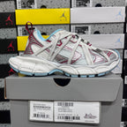 White Balenciaga sneaker with red panel lines and light blue outsole, shown on box