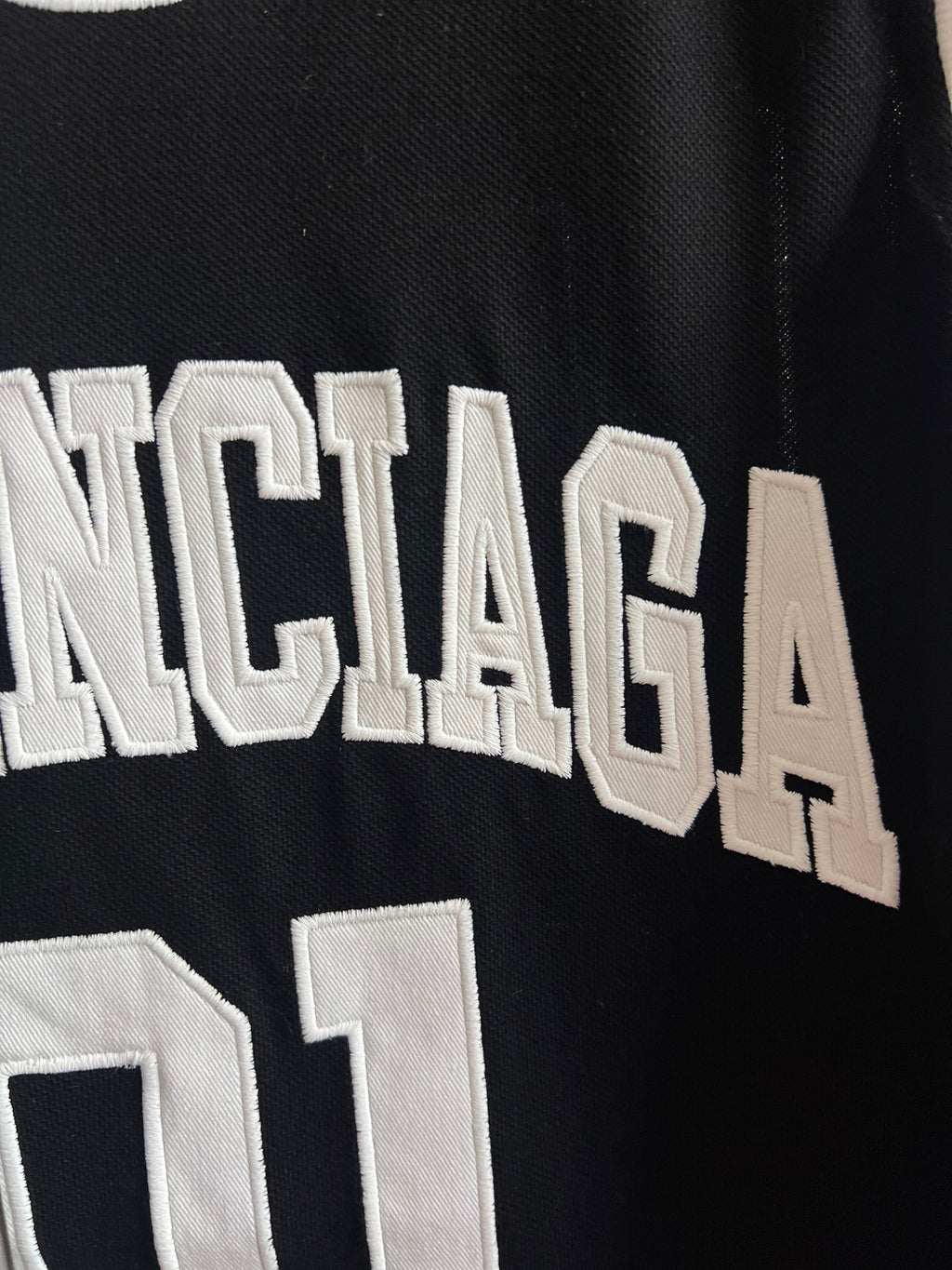 Black basketball jersey close-up of white Balenciaga lettering across the chest