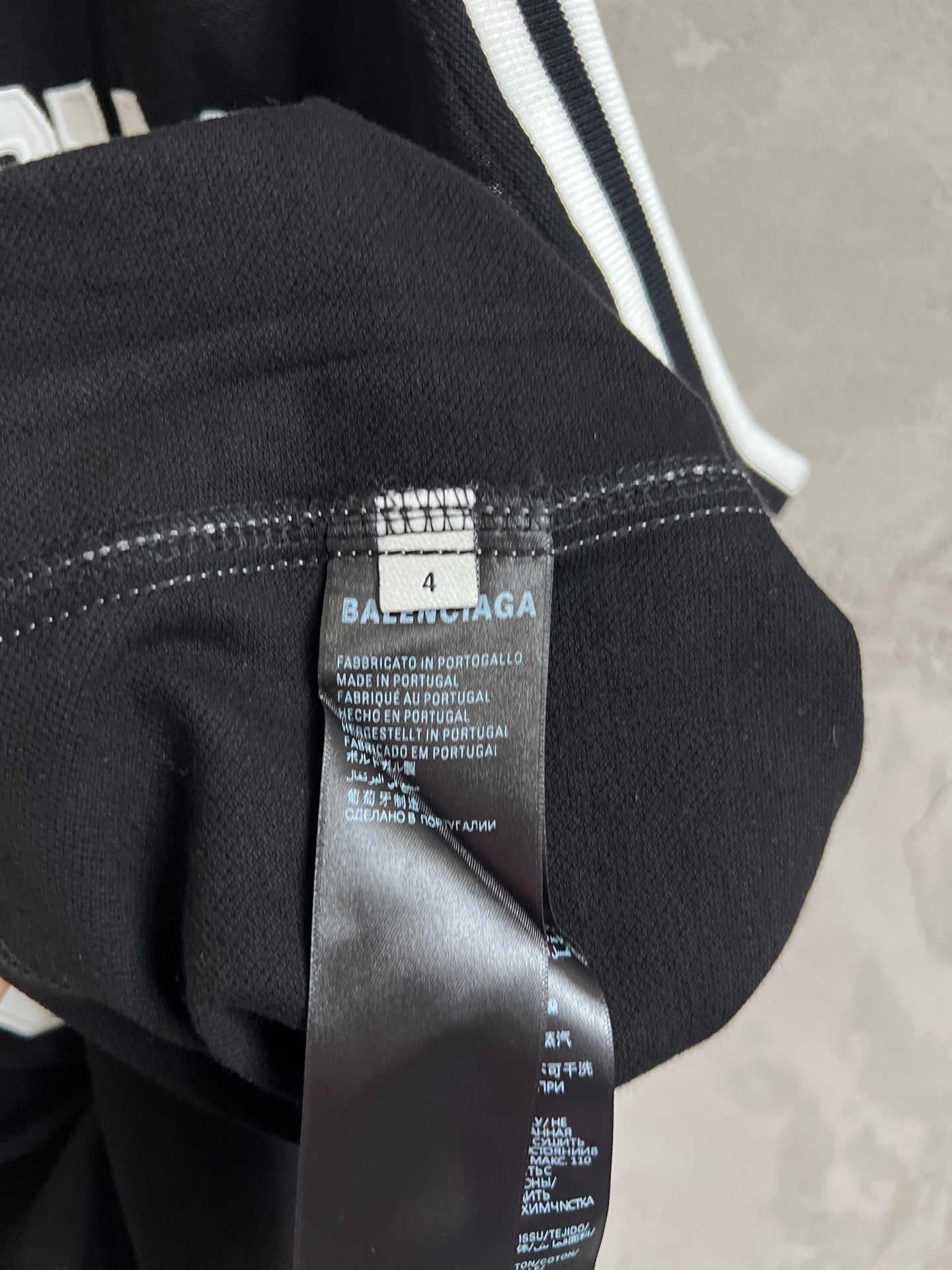 Black jersey fabric close-up with interior care label and tag