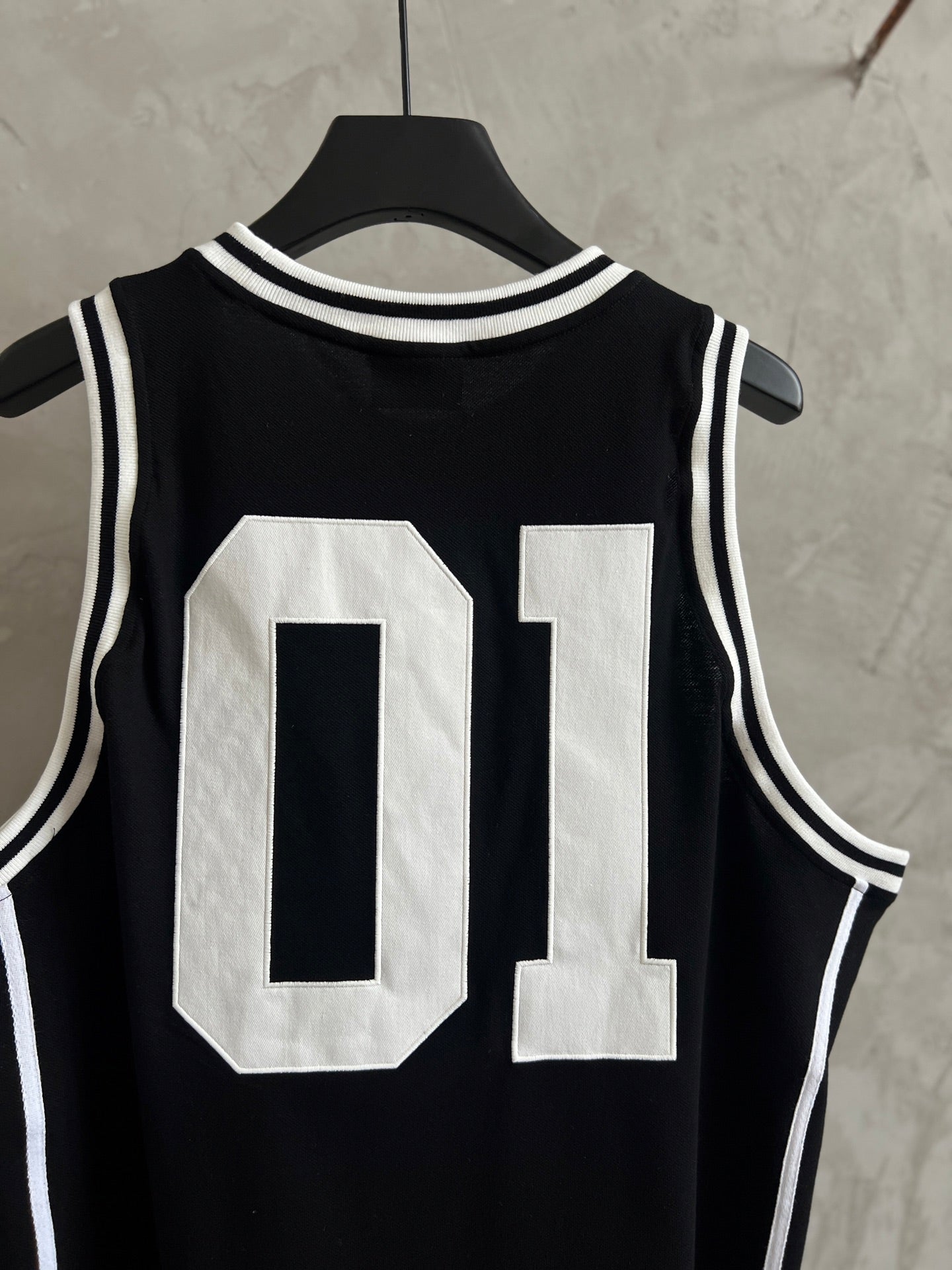 Black basketball jersey front with large white 01 number graphic and white trim