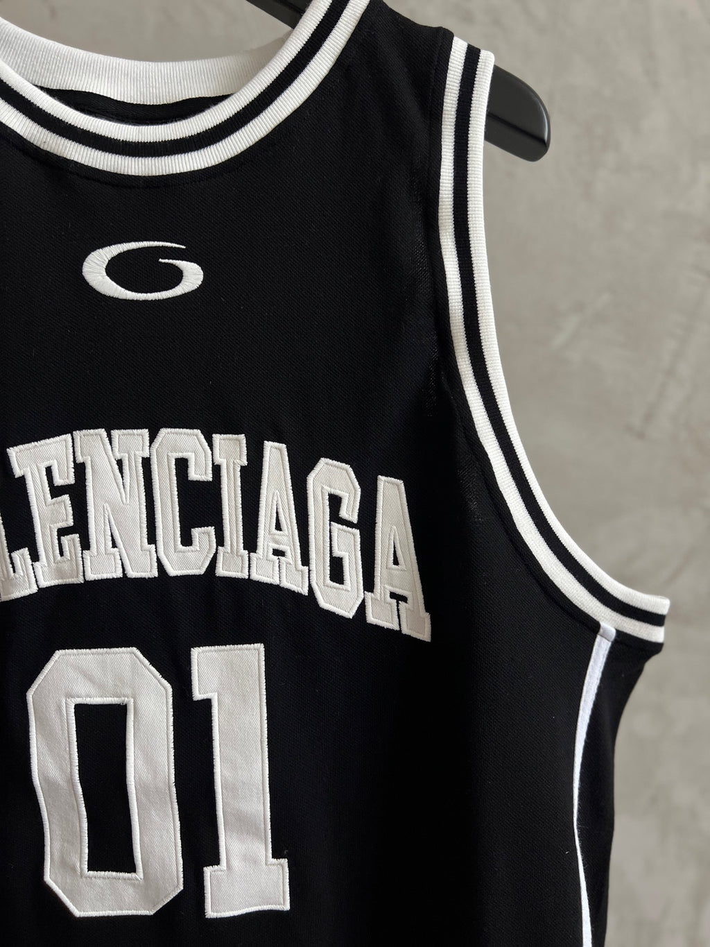 Black basketball jersey close-up with Balenciaga lettering and 01 number