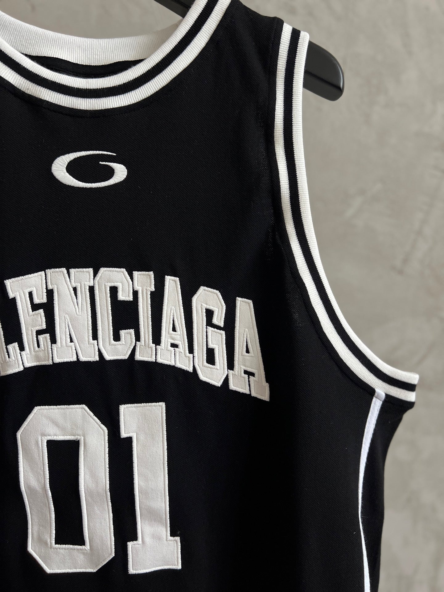 Black basketball jersey close-up with Balenciaga lettering and 01 number