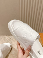 White embossed monogram slide sandal with wide strap and cushioned footbed