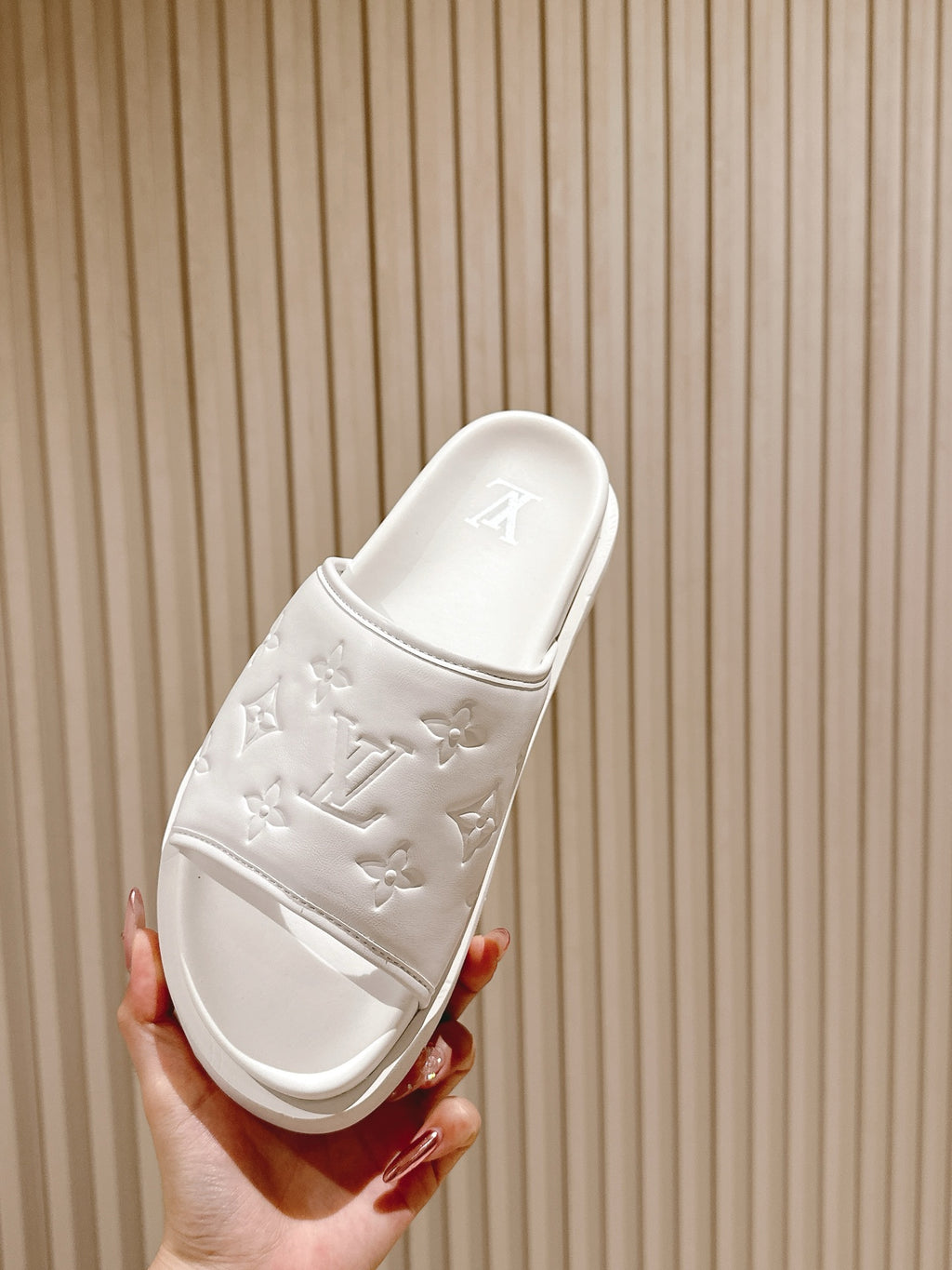 White slide sandals with embossed monogram on strap and contoured footbed