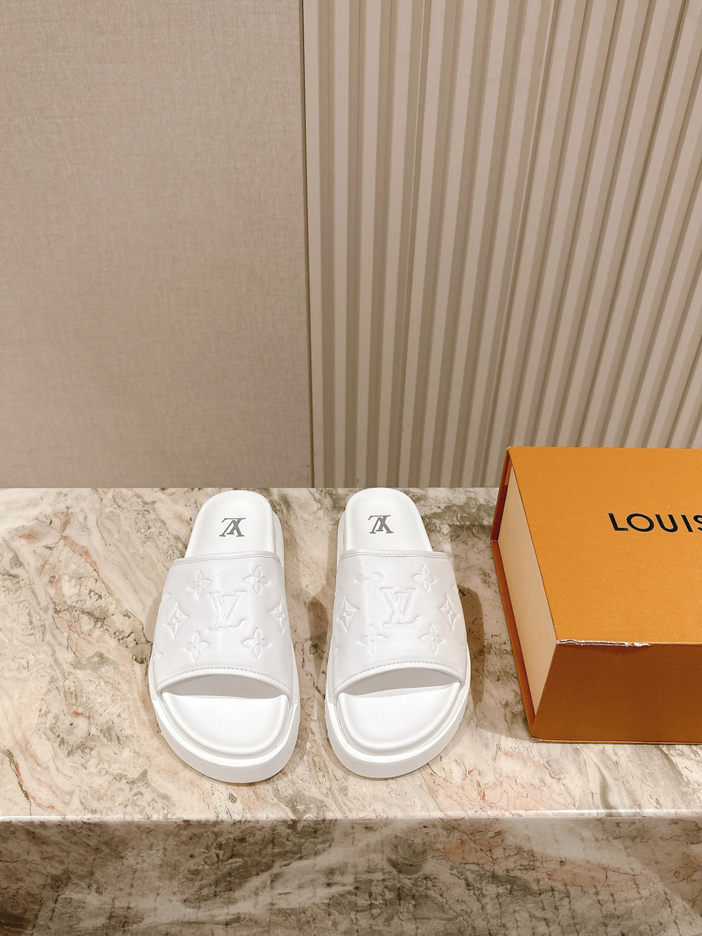 White slide sandals with embossed monogram and open toe, slip-on sole