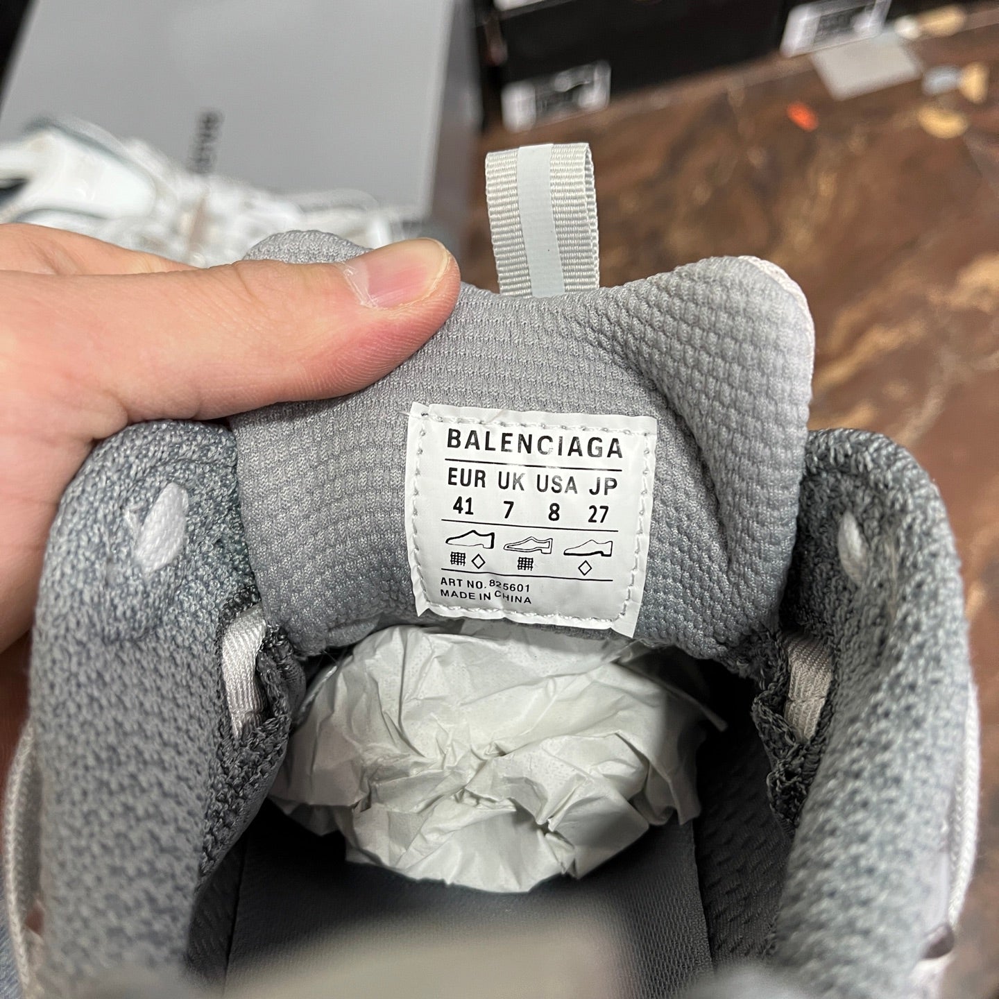Unisex light gray sneaker tongue label with size markings, interior heel opening visible