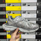 Unisex light gray sneakers held up for display, lace-up front and thick midsole