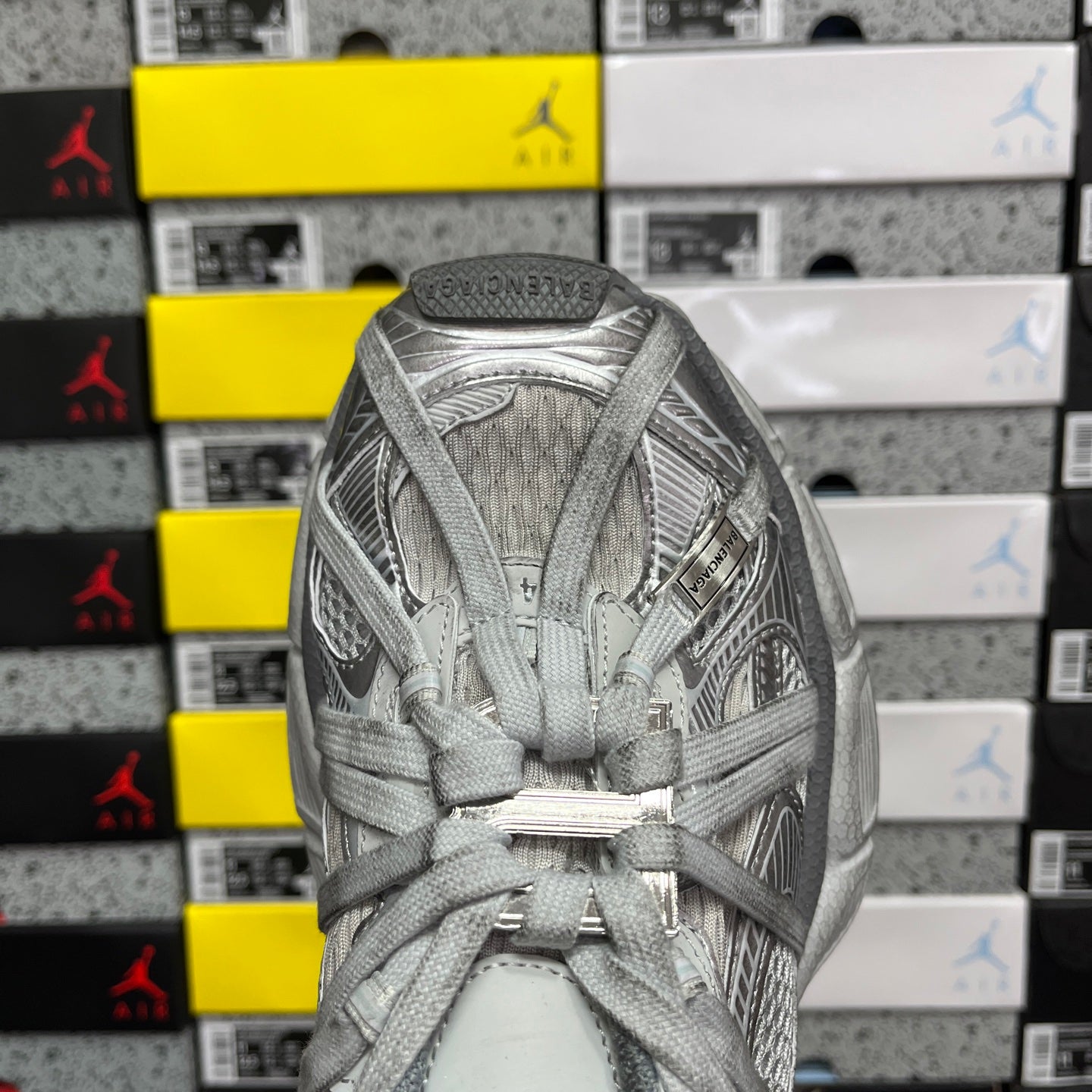 Unisex light gray sneakers viewed from toe, showing laces and textured knit upper