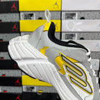 White unisex sneaker with yellow side logo, black collar, and lace-up tongue