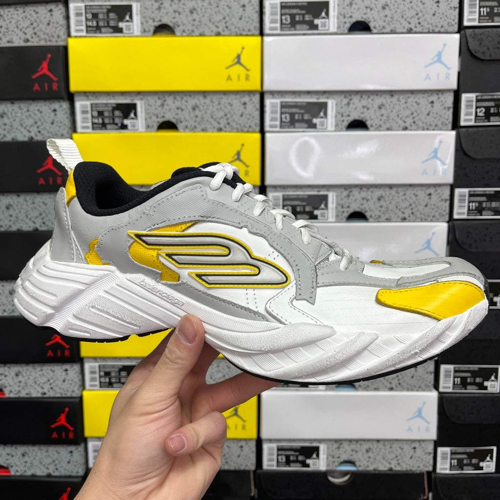 White and yellow unisex sneakers with black collar and oversized side logo