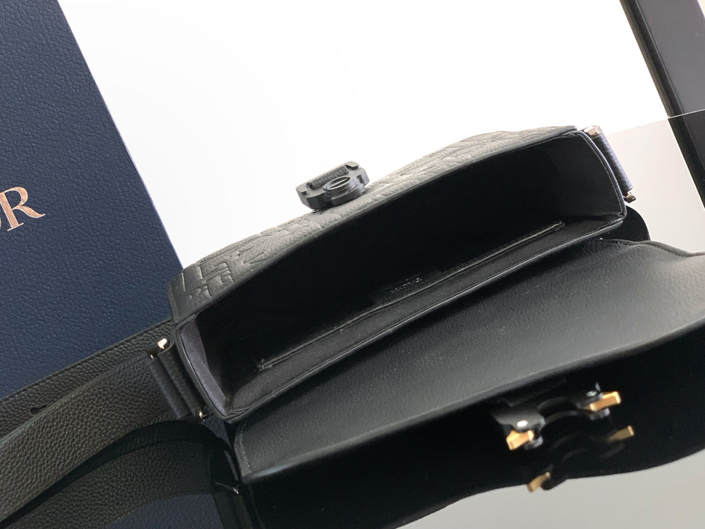 Dior bag interior view with dark lining and top flap closure and hinge hardware