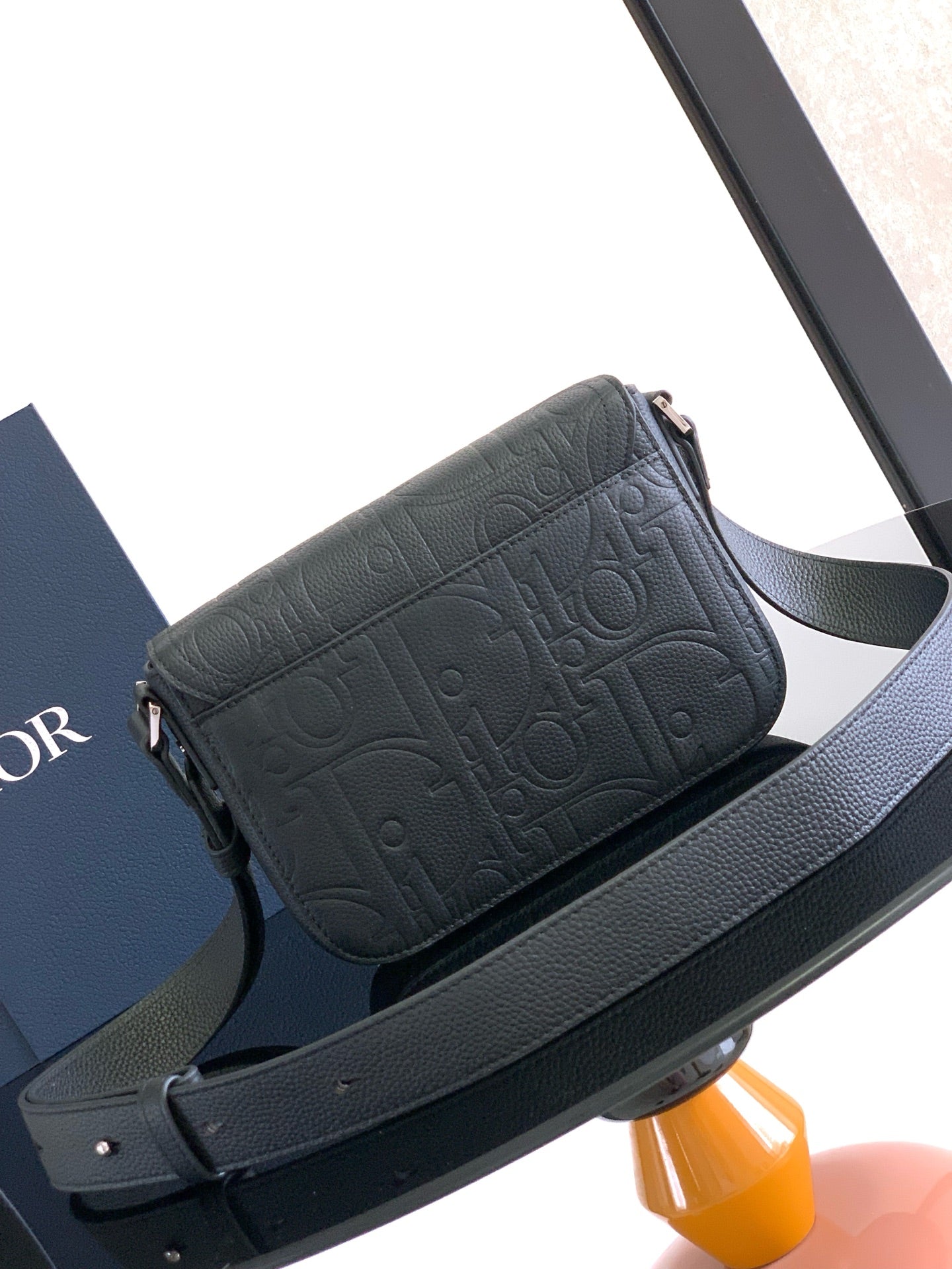 Dior flap crossbody bag in dark textured leather with strap and clasp closure