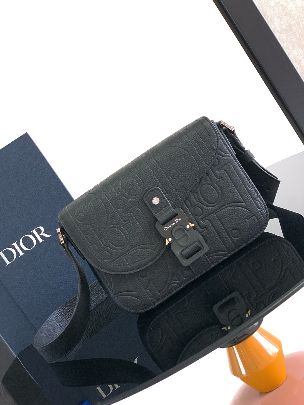 Dior shoulder bag in dark textured leather with embossed pattern and front buckle