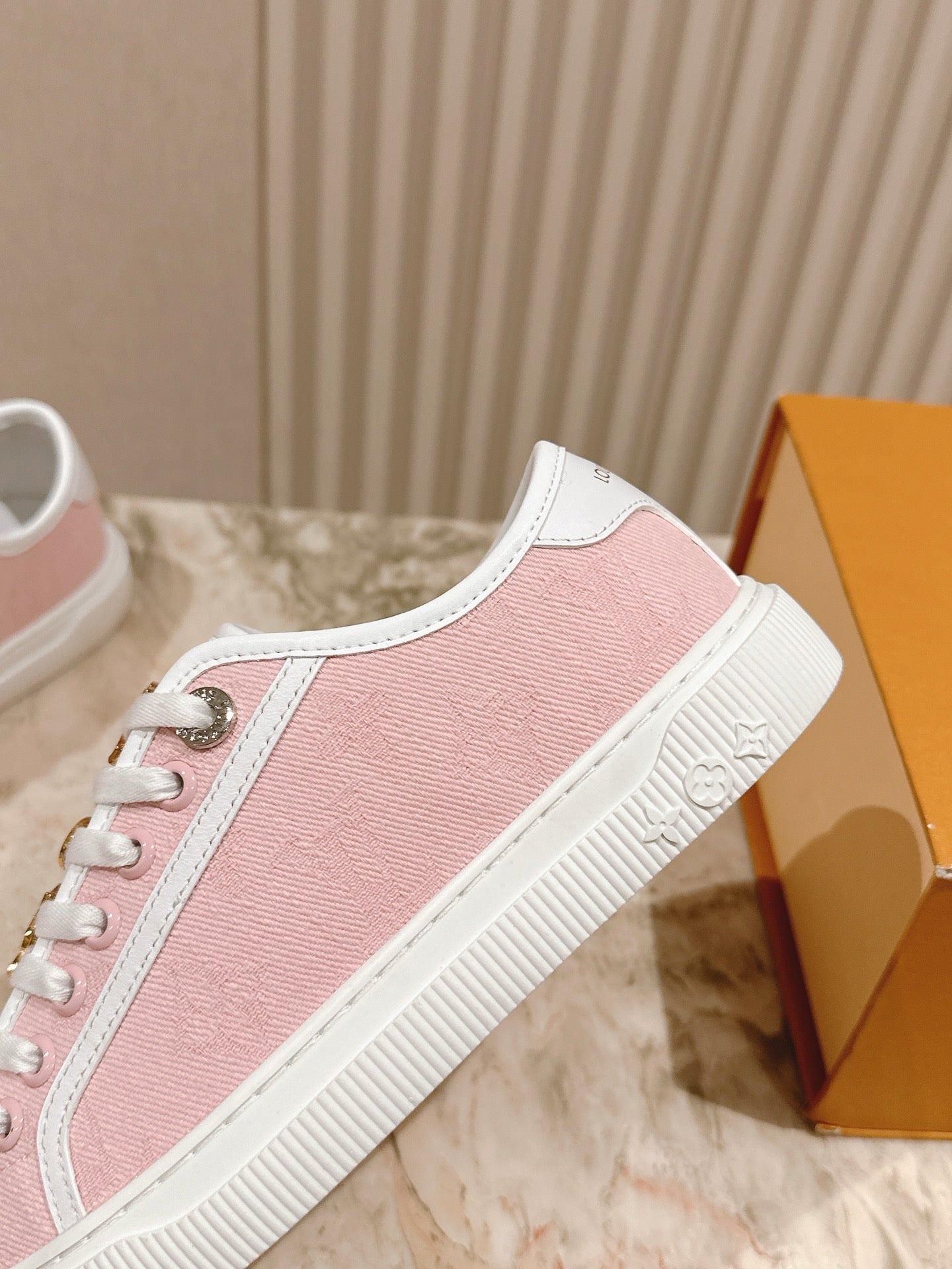 Pink slip-on style sneakers with textured white sole and decorative lace panel