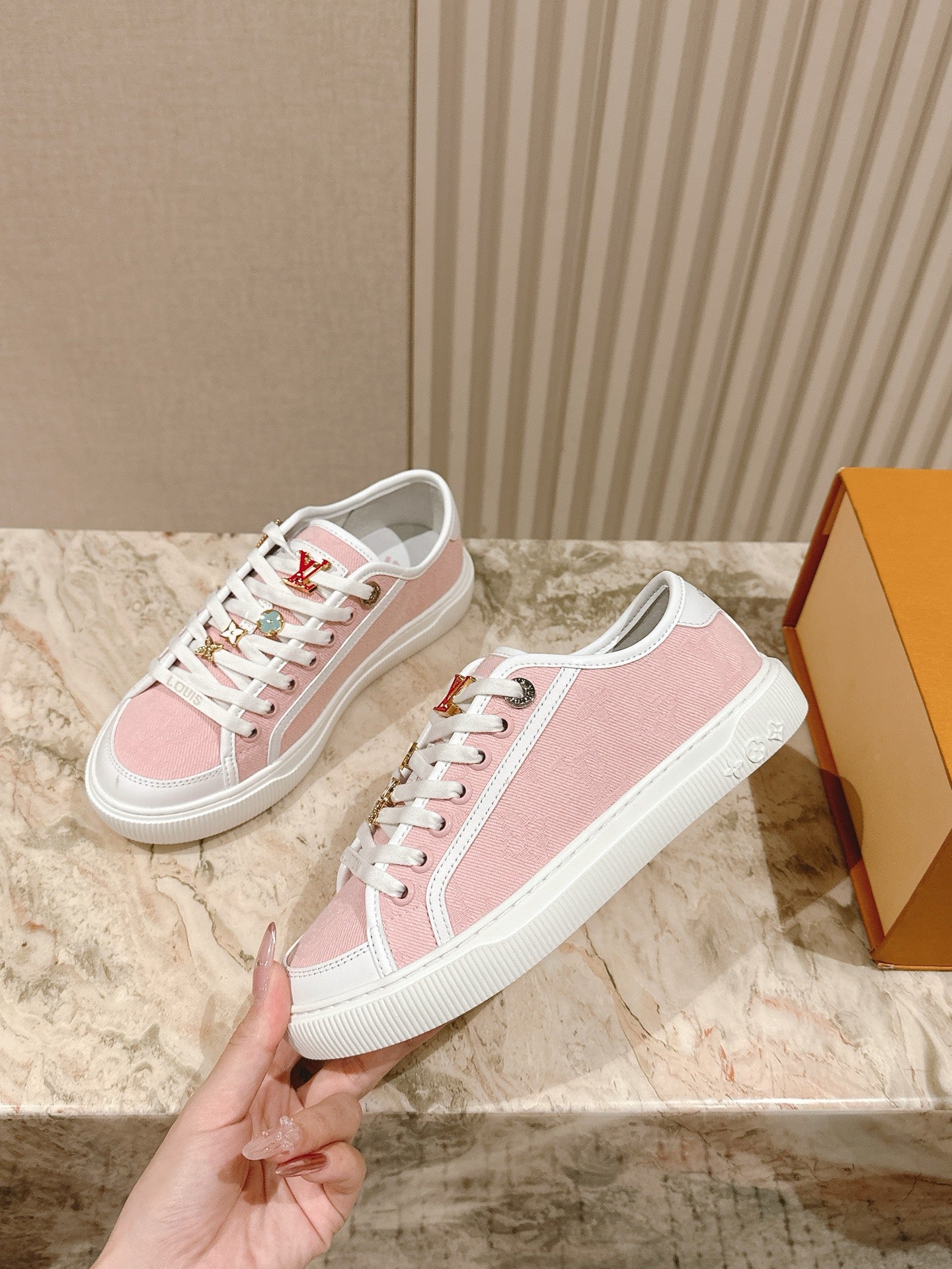 Pink and white low-top sneakers with white laces and side logo details