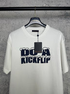 White T-shirt front with navy "DO A KICKFLIP" graphic and attached hanging tag