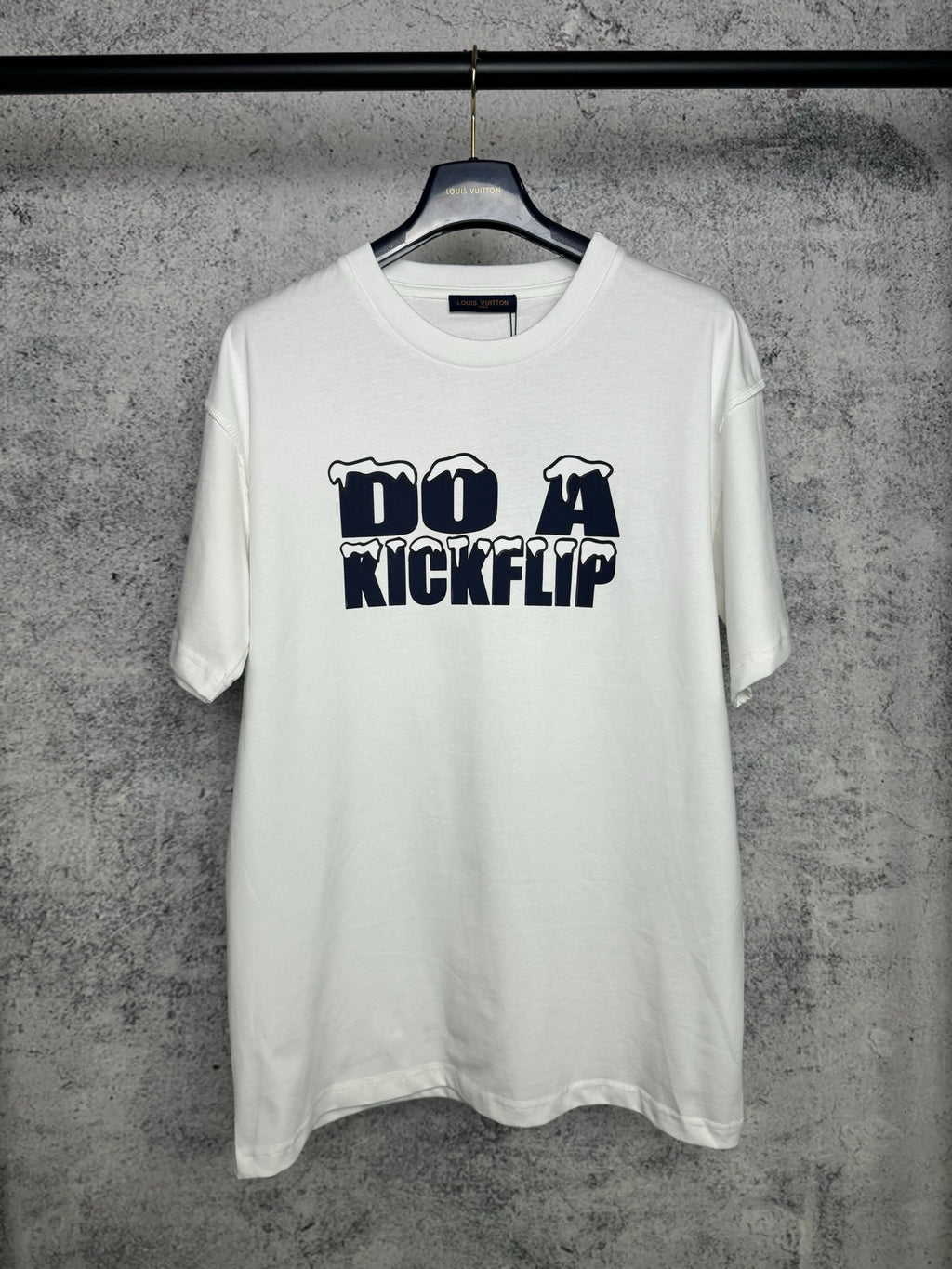 White T-shirt with navy "DO A KICKFLIP" graphic on the chest