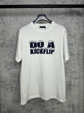 White T-shirt with navy "DO A KICKFLIP" graphic on the chest