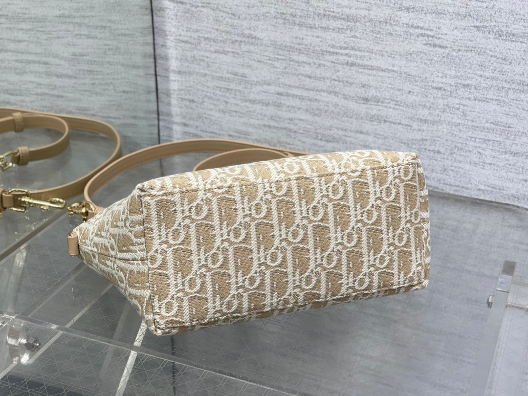 Beige Dior monogram pouch bag with curved zipper top and shoulder strap