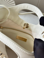 Chanel cream handbag interior with zip pocket, gold-tone clasp, and Chanel logo plate