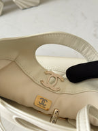 Chanel cream handbag close-up with gold-tone turnlock and interior Chanel logo patch