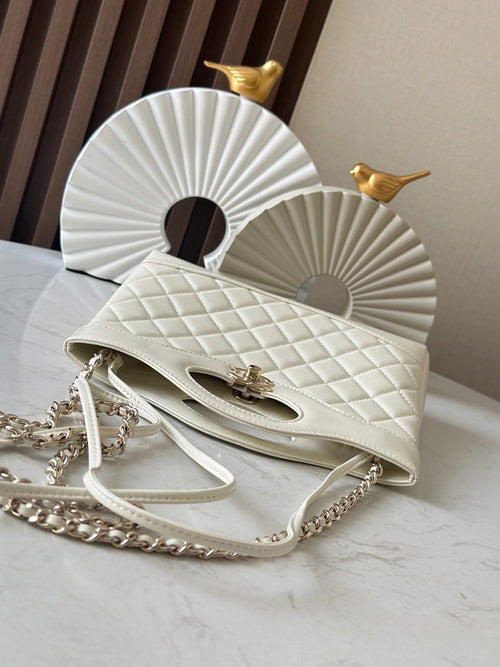 Chanel cream quilted handbag with chain strap, open top, and gold-tone turnlock detail