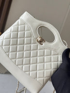 Chanel cream quilted handbag front close-up with oval handle opening and gold-tone clasp