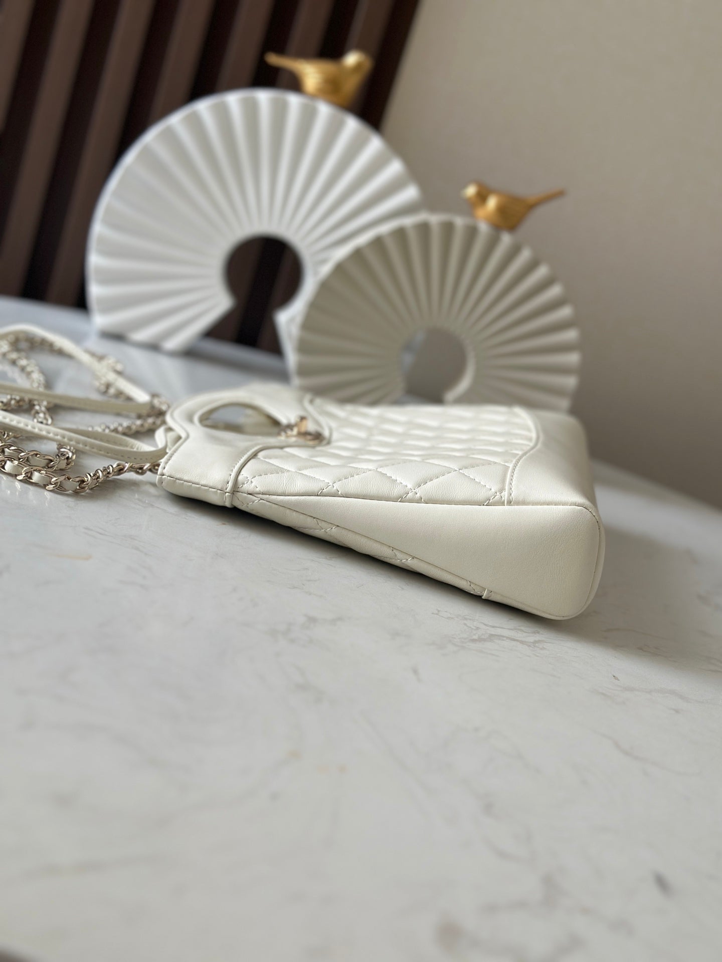 Chanel cream handbag with quilted front, chain strap, and gold-tone handle hardware