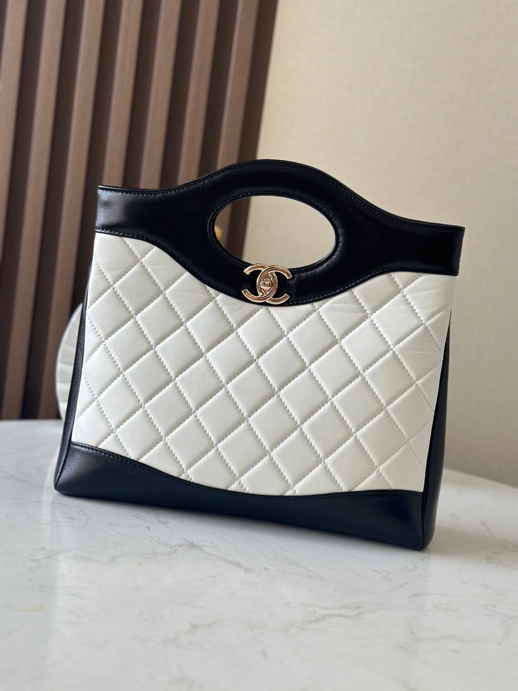 Chanel quilted handbag with dark trim and top handle ring, front view