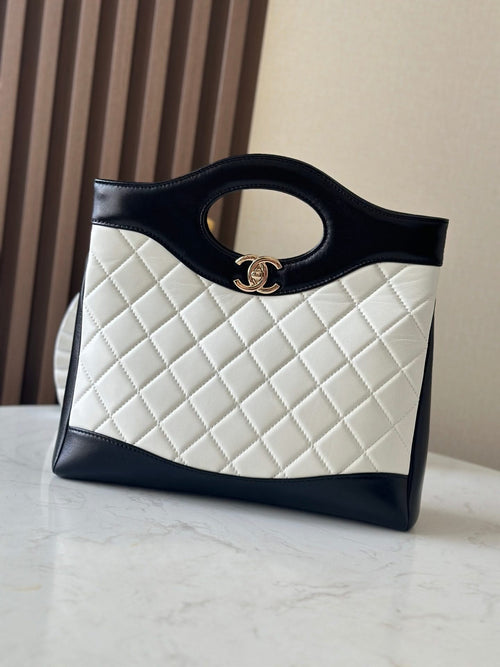 Chanel quilted handbag with dark trim and top handle ring, front view