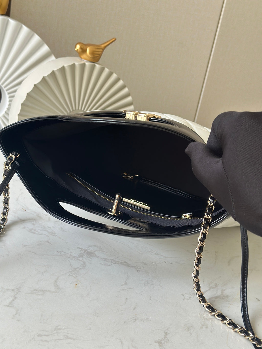 Chanel handbag interior view with zipper, gold hardware, and chain strap