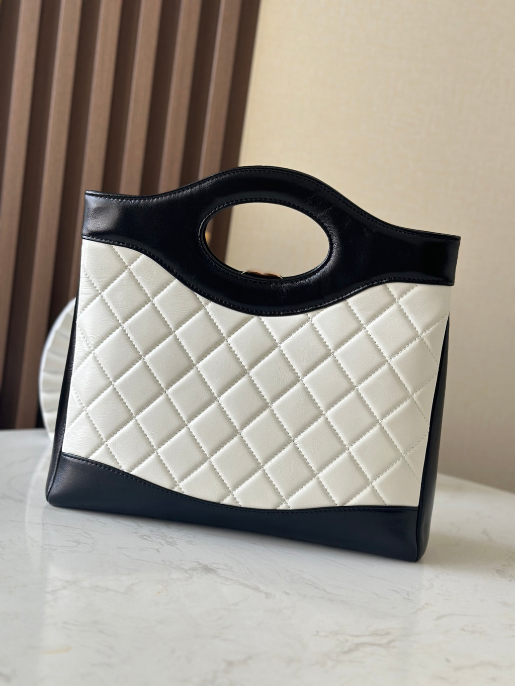 Chanel quilted handbag with light body and dark trim, front view