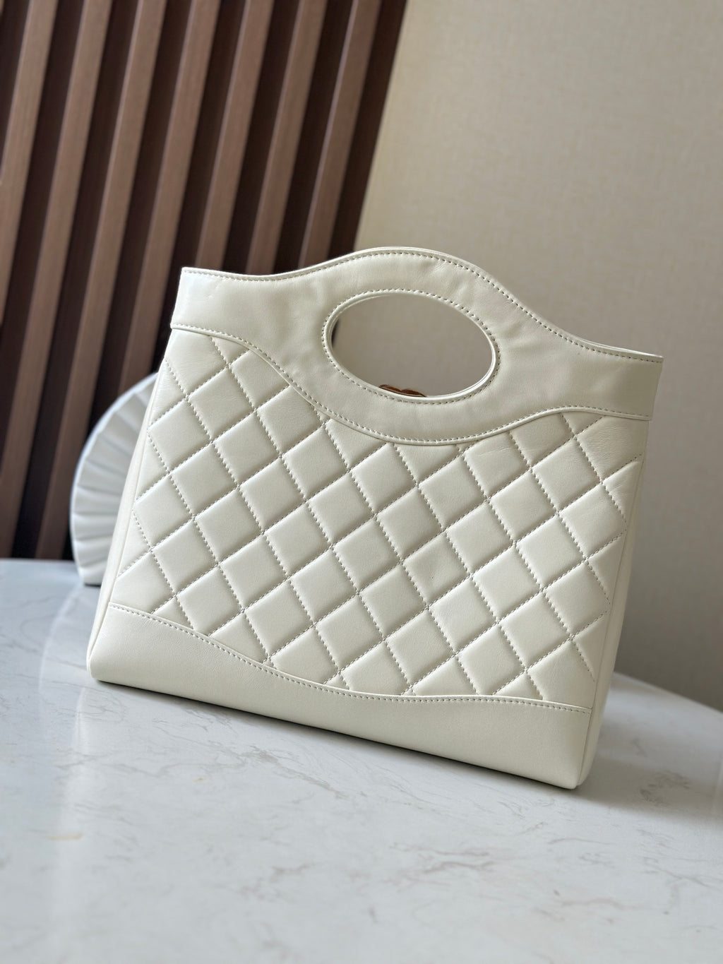 White Chanel tote-style bag with diamond quilting and CC logo at front.
