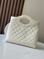 White Chanel tote-style bag with diamond quilting and CC logo at front.