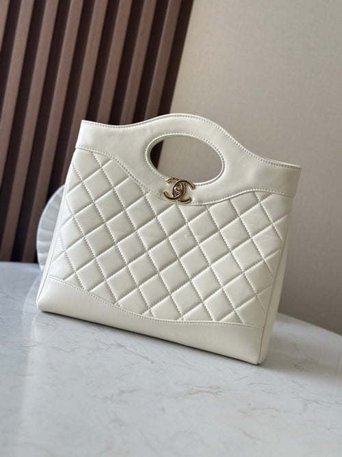 Quilted Chanel tote bag in white with CC logo and rounded cutout handle.