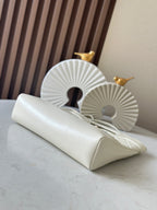 White Chanel flap bag with chain strap and gold hardware, angled side view.